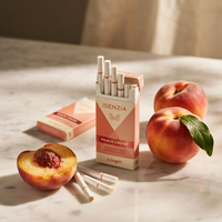 ISENZIA peach crush cigarettes on a marble surface with peaches